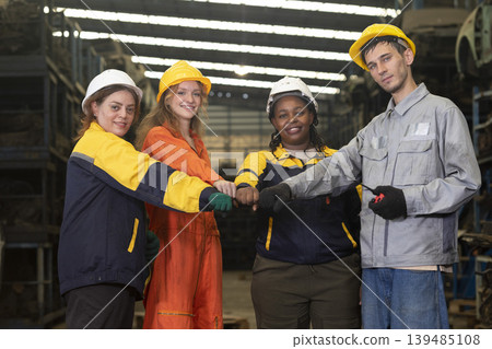 Group worker factory or engineer men and women standing with confidence and success. People discussing in workplace of warehouse industrial factory. Group worker factory or engineer men and women standing with confidence and success. People discussing in workplace of warehouse industrial factory. 139485108