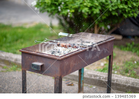 Rustic charcoal barbecue grill with skewers outdoors 139485369