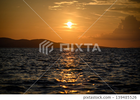 Golden sunset over ocean with island silhouettes Golden sunset over ocean with island silhouettes 139485526