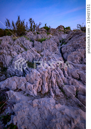 Rugged limestone rock formations under blue evening sky Rugged limestone rock formations under blue evening sky 139485551