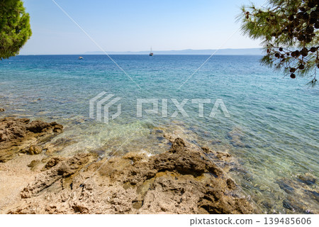 Rocky coast with clear turquoise sea and sailboats 139485606