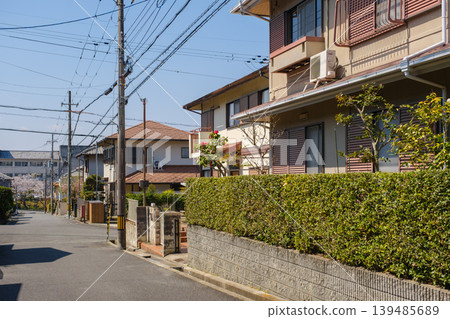 春天,櫻花盛開,寧靜的住宅區;藍天白雲,丘陵起伏,展現出一幅日式街景。 春天,櫻花盛開,寧靜的住宅區;藍天白雲,丘陵起伏,展現出一幅日式街景。 139485689