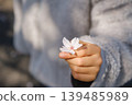 孩子的小手捧著一朵櫻花：沐浴在春日陽光下的溫柔時刻。 139485989