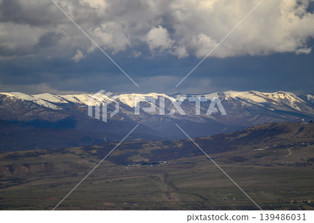 Snow-capped mountain range under dramatic clouds Snow-capped mountain range under dramatic clouds 139486031