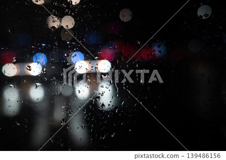 Rain on Window at Night with Blurred City Lights. Moody Urban Background. Raindrops Rain on Window at Night with Blurred City Lights. Moody Urban Background. Raindrops 139486156