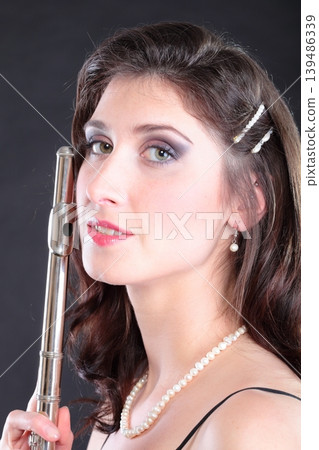 girl and flute on a black background girl and flute on a black background 139486339