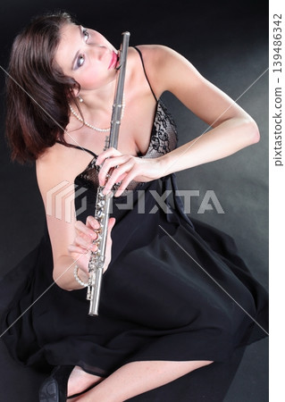 girl and flute on a black background girl and flute on a black background 139486342