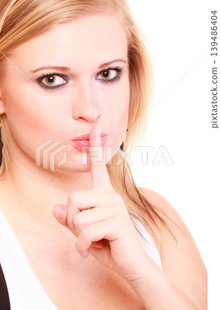 Portrait of blonde woman making silence gesture 139486404
