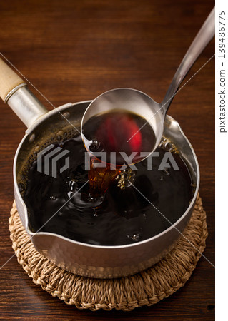 用湯匙舀麵條湯。 用湯匙舀麵條湯。 139486775