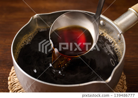 用湯匙舀麵條湯。 用湯匙舀麵條湯。 139486777