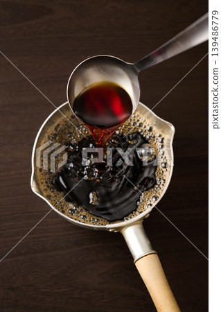 用湯匙舀麵條湯。 用湯匙舀麵條湯。 139486779