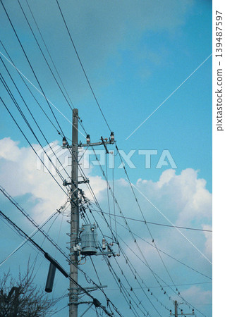 A cloudy blue sky and a telephone pole A cloudy blue sky and a telephone pole 139487597