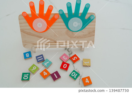 Math learning board with scattered number blocks on a table. The scene represents playful and interactive education for children. Math learning board with scattered number blocks on a table. The scene represents playful and interactive education for children. 139487730