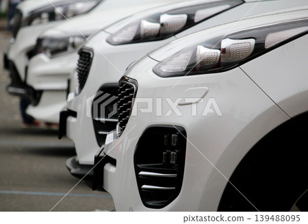 The same white vehicles lined up on the street  139488095