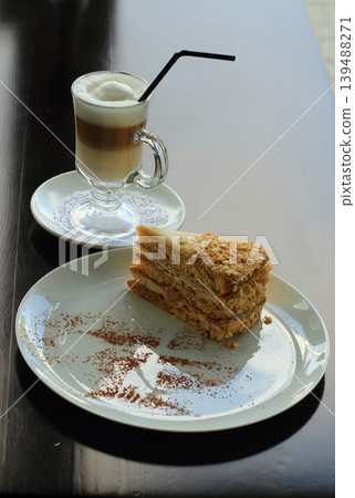 Sweet puff pastry Napoleon cake and milk coffee on the bar table at cake shop Sweet puff pastry Napoleon cake and milk coffee on the bar table at cake shop 139488271