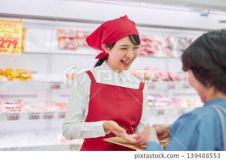 A young woman working at a supermarket's sample counter 139488553