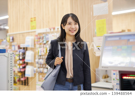 一位年輕女子正在使用智慧型手機在自助結帳櫃檯付款。 一位年輕女子正在使用智慧型手機在自助結帳櫃檯付款。 139488564