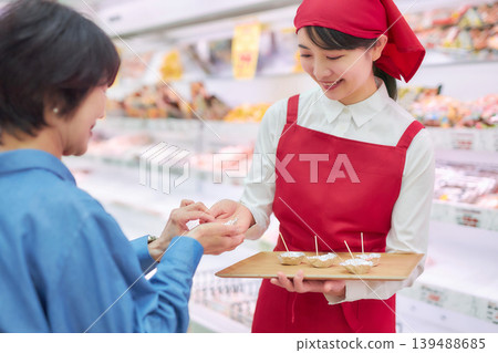A young woman working at a supermarket's sample counter 139488685