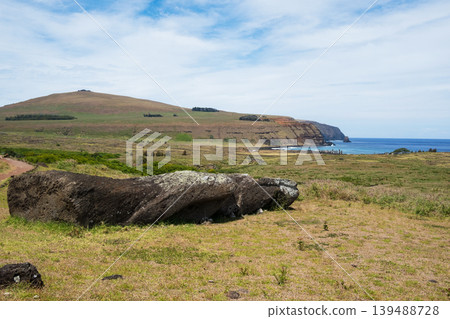 A fallen Moai statue on Rano Raraku Hill with Ahu Tongariki visible in the distance, Easter Island, November 2025. A fallen Moai statue on Rano Raraku Hill with Ahu Tongariki visible in the distance, Easter Island, November 2025. 139488728