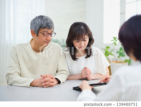 一位女銷售員正在向一對夫婦講解如何使用平板電腦 139488751