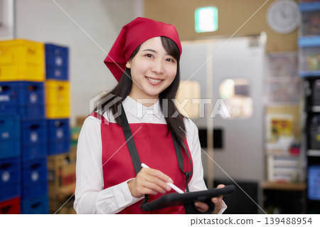 一位年輕女子在後屋使用平板電腦管理庫存。 139488954