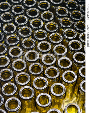 Several glass bottles arranged in neat rows on a surface showing the top ends and inner details of the containers at a production facility Several glass bottles arranged in neat rows on a surface showing the top ends and inner details of the containers at a production facility 139489829
