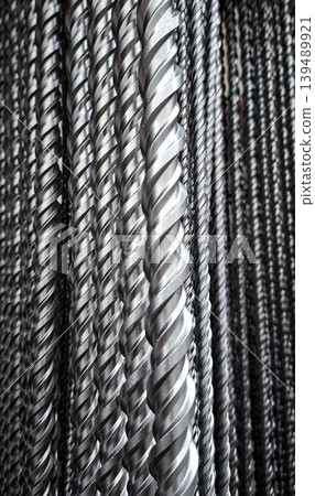 Long steel drill bits are lined up in a row, showing the spiral flutes. These tools are used for metalworking and precision engineering in various manufacturing processes. Long steel drill bits are lined up in a row, showing the spiral flutes. These tools are used for metalworking and precision engineering in various manufacturing processes. 139489921