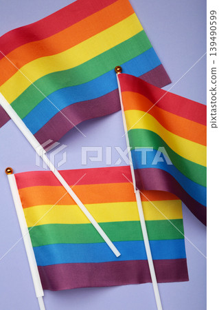 LGBT rainbow flag flat lay on purple background. Space for text. Vertical photo LGBT rainbow flag flat lay on purple background. Space for text. Vertical photo 139490599