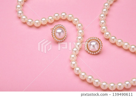 Beautiful pearl earring and necklace on pink background Beautiful pearl earring and necklace on pink background 139490611