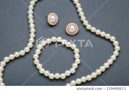 Beautiful pearl bracelet, earring, and necklace on dark blue background Beautiful pearl bracelet, earring, and necklace on dark blue background 139490613