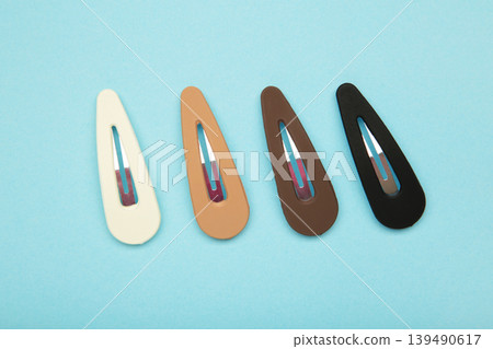 Colored pastel hair clips on blue background. 139490617