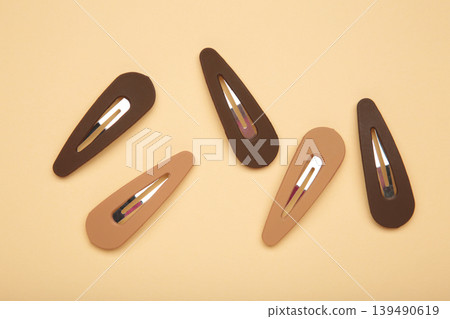 Beige and brown hair clips on beige background. Space for text 139490619