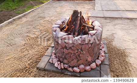 Stone fire pit in the backyard. Space for text Stone fire pit in the backyard. Space for text 139490629