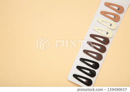 Colored pastel hair clips on beige background. Space for text Colored pastel hair clips on beige background. Space for text 139490637