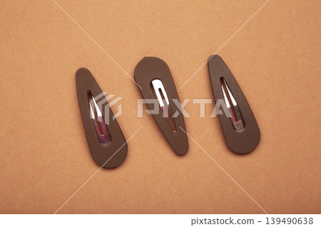 Brown hair clips on brown background. Brown hair clips on brown background. 139490638