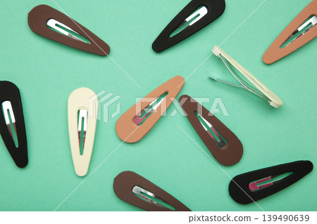 Colored pastel hair clips on mint background. Colored pastel hair clips on mint background. 139490639