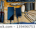 Woodworking chisels and blanks on a workbench with a smartphone charging at 1 percent battery. 139490753
