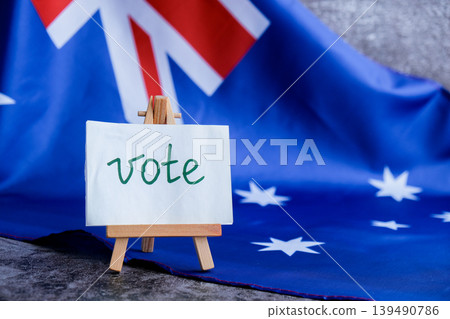 Aussie flag near text VOTE for electoral campaigns. Minimalist patriotic message board with VOTE and national backdrop. Concept of civic participation and democratic choice useful for government Aussie flag near text VOTE for electoral campaigns. Minimalist patriotic message board with VOTE and national backdrop. Concept of civic participation and democratic choice useful for government 139490786