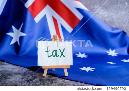 Message text TAX beside Australian flag for government or finance communication. National identity for tax awareness campaigns. Concept of revenue, legislation 139490790
