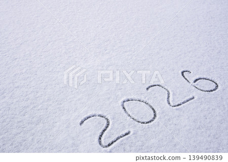 Written sketch for new year 2026. Snow background numbers ice outdoor on ground in winter. Writing text sign and drawing on field in nature frozen background. Copy space 139490839