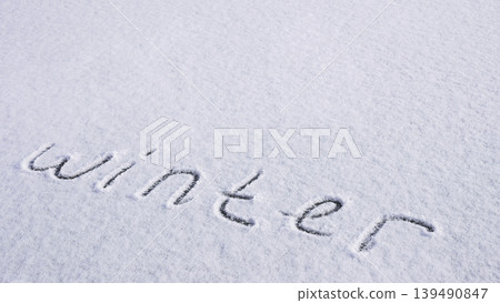 Written WINTER on snow background message ice outdoor on ground in winter. Writing text sign and drawing on field in frozen background. Weather is changing cold season has arrived. Mockup Copy space 139490847