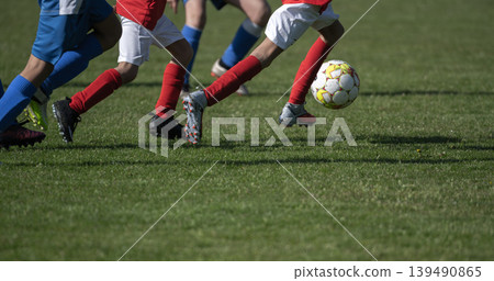 Youth Soccer Players Running After Ball on Grass Field Youth Soccer Players Running After Ball on Grass Field 139490865