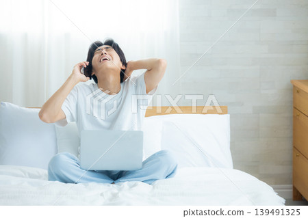 A man who plays a computer at bed A man who plays a computer at bed 139491325