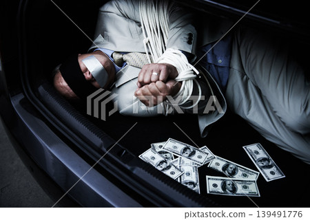 Man, tied up and kidnap in car with money, ransom and crime for wealth, debt or financial negotiation. Person with blindfold, rope and cash in trunk for abduction, danger and risk or scared for life 139491776