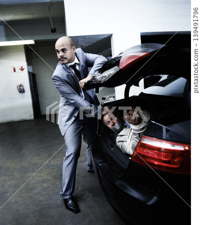 Man in car, kidnapping and mafia with danger, fear and violence in basement garage. Crime, human trafficking and scared person tied with rope in trunk in parking lot with gangster, ransom and terror. Man in car, kidnapping and mafia with danger, fear and violence in basement garage. Crime, human trafficking and scared person tied with rope in trunk in parking lot with gangster, ransom and terror. 139491796