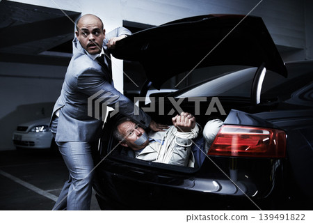 Man in car, kidnapping and mafia with fear, danger and violence in basement garage. Crime, human trafficking and scared person tied with rope in trunk in parking lot with gangster, ransom and terror. 139491822