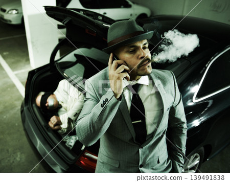 Phone call, car and man with abduction in trunk for negotiation, kidnapping ransom and crime. Mafia, gangster criminal and person smoking in boot for terrorism, danger and robbery in parking lot 139491838