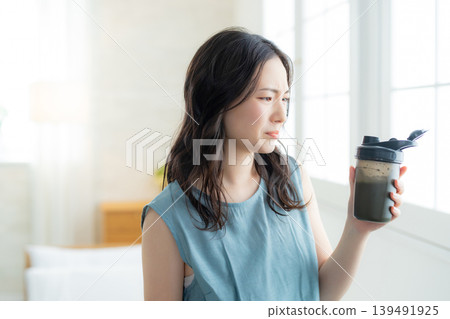  Woman drinking protein 139491925