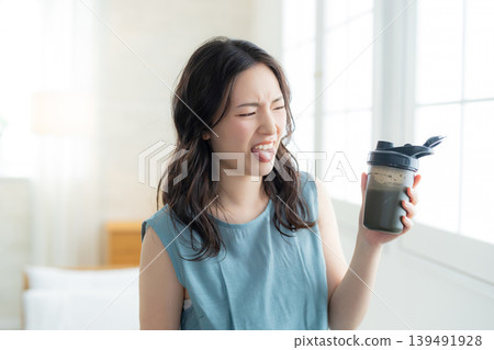  Woman drinking protein 139491928