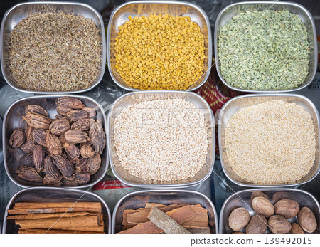 Assortment of spices and seeds, top view. Different seasonings, spices in the metal plates Assortment of spices and seeds, top view. Different seasonings, spices in the metal plates 139492015